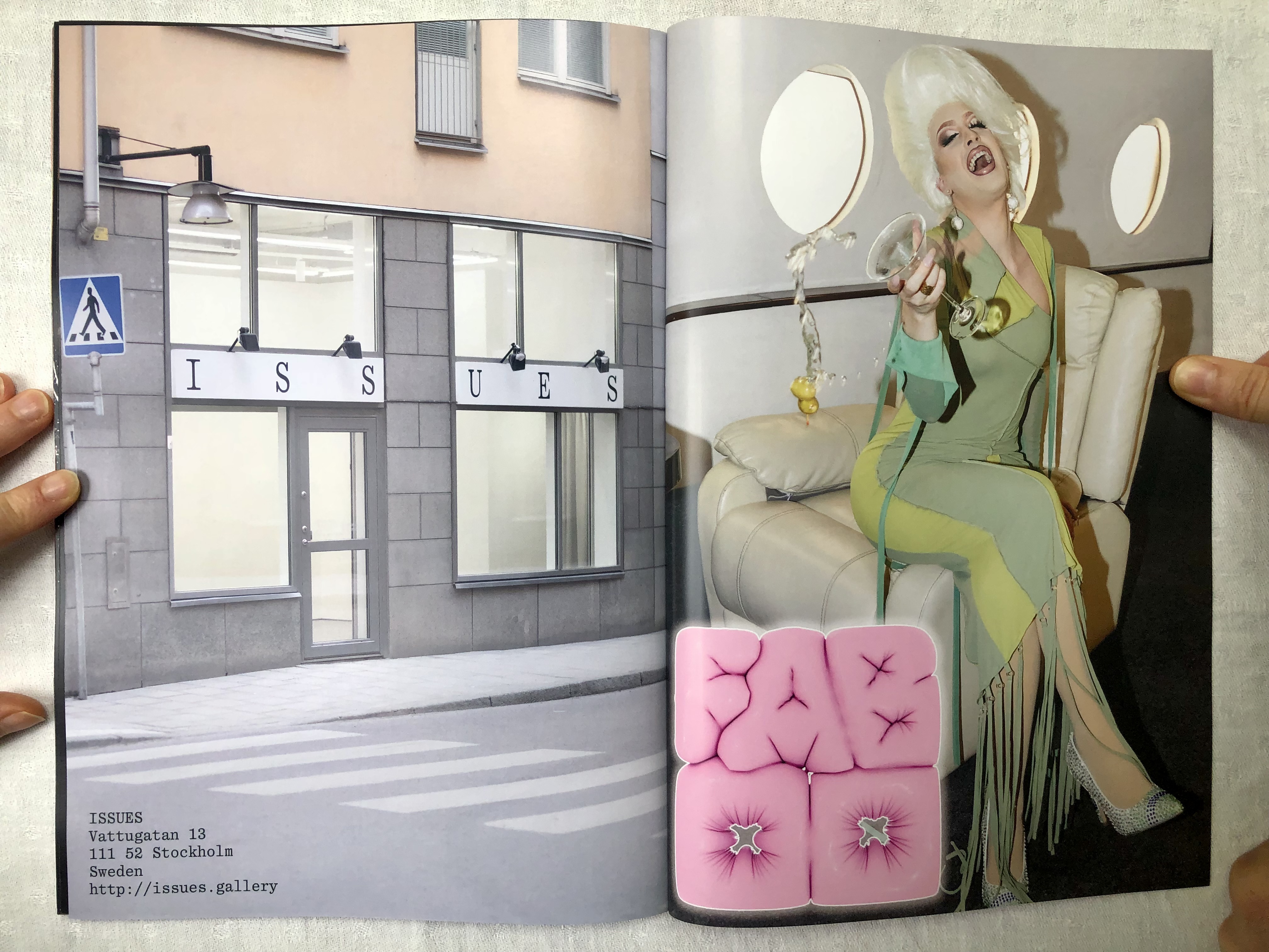 Magazine spread against a gray background. The left page shows a photo of the exterior of Issues Gallery in Stockholm. The right page shows Jesse in campy drag laughing with a martini glass on a private jet.